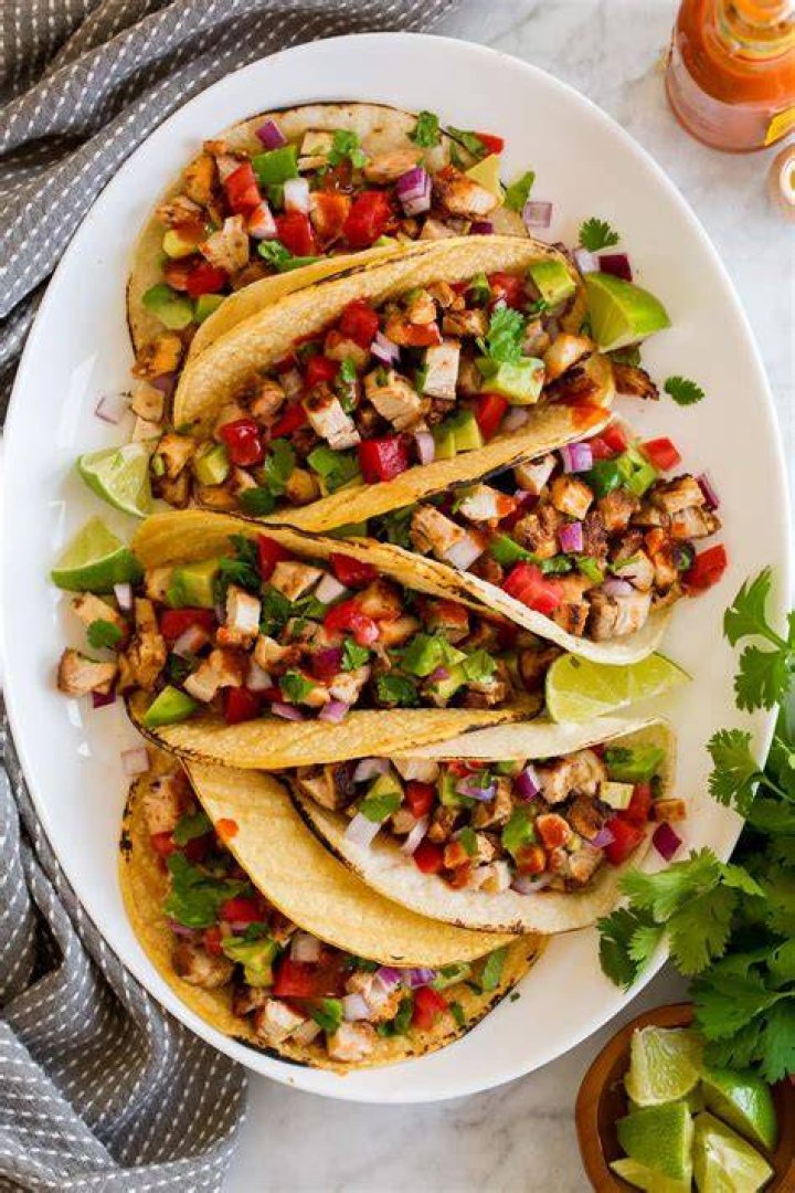 Chicken tacos on a white plate.