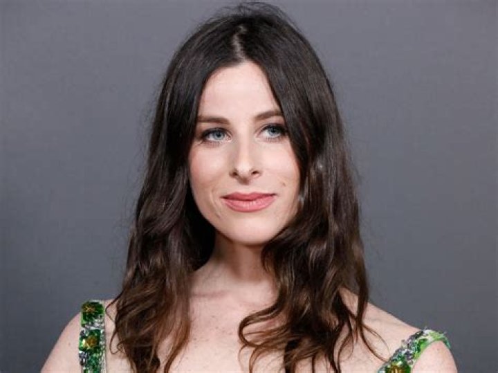 Sasha Spielberg in a green dress poses for a picture.